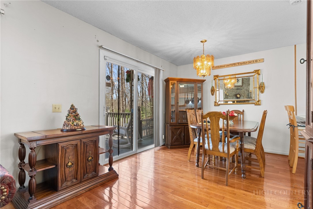 271 Quail Hollow Road Crumpler, NC 28617 - Photo 11 of 30 a dining room with furniture a chandelier and wooden floor