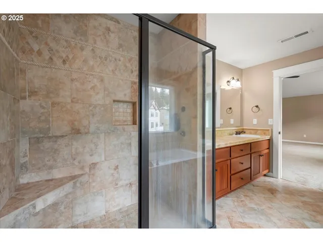a bathroom with a granite countertop sink mirror and shower