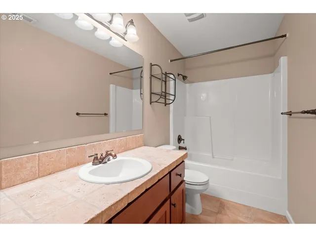 a bathroom with a sink toilet a mirror and shower