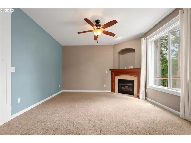 a view of an empty room with window and fireplace