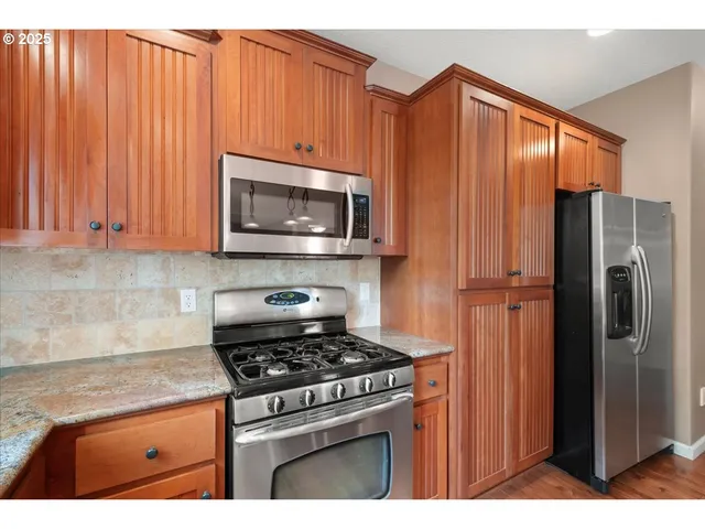 a kitchen with stainless steel appliances wooden cabinets and a stove top oven