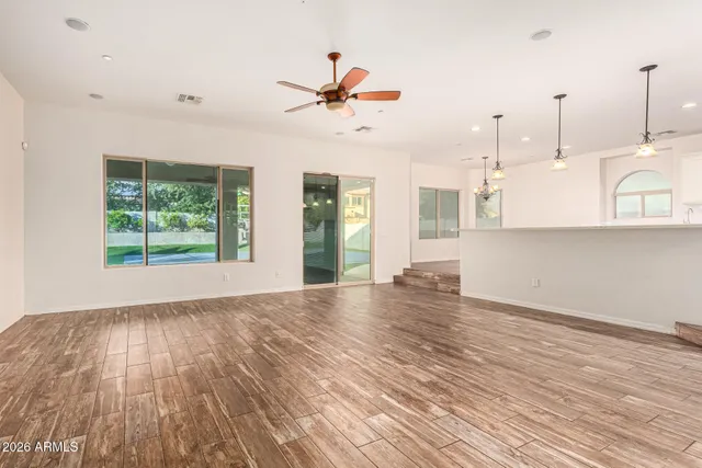 a view of a kitchen with kitchen island stainless steel appliances wooden floor and a chandelier
