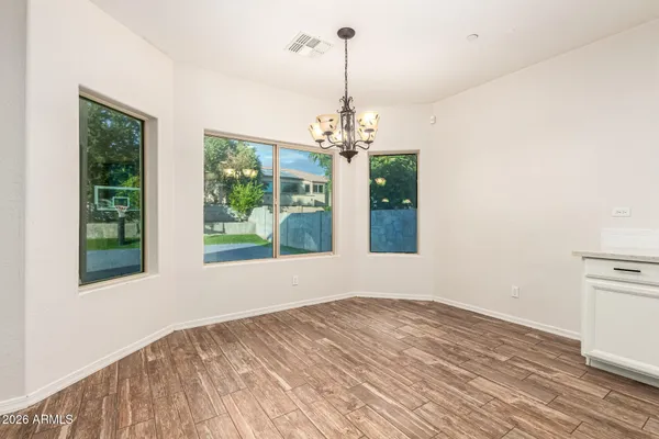 a view of a kitchen with kitchen island wooden floor appliances and a window