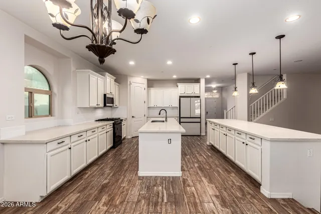 a kitchen with white cabinets and refrigerator