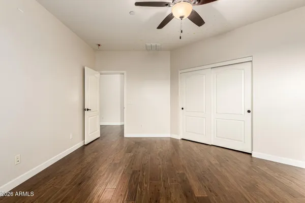 a view of a livingroom with wooden floor and a ceiling fan