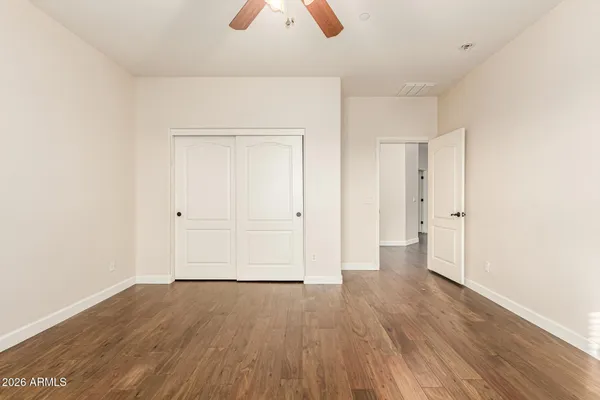 a view of a livingroom with wooden floor and a ceiling fan