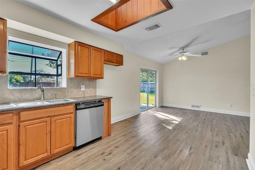 7724 Pengrove Pass Orlando, FL 32835 - Photo 11 of 24 a kitchen with granite countertop wooden floors and wide window