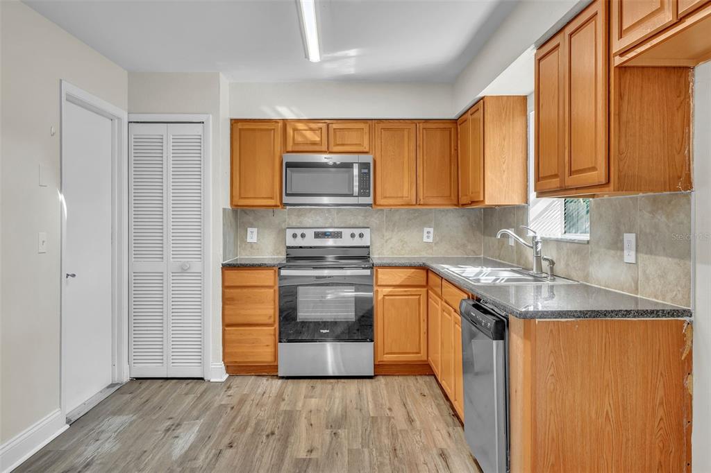 7724 Pengrove Pass Orlando, FL 32835 - Photo 12 of 24 a kitchen with stainless steel appliances granite countertop a stove a sink and a microwave