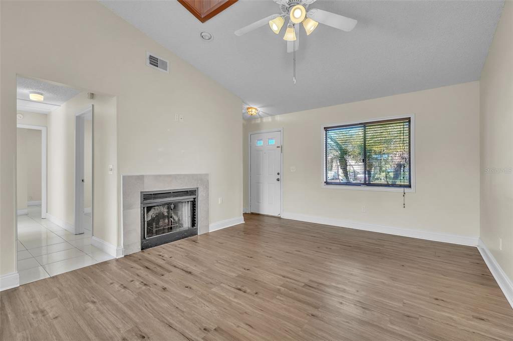 7724 Pengrove Pass Orlando, FL 32835 - Photo 4 of 24 an empty room with windows fireplace and fans