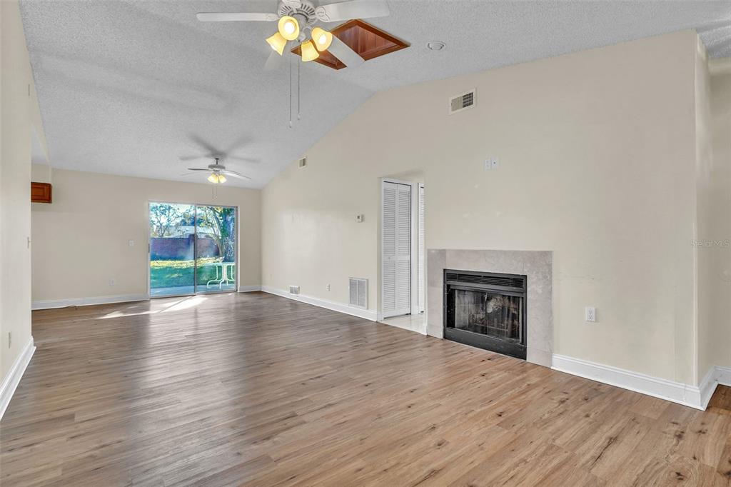 7724 Pengrove Pass Orlando, FL 32835 - Photo 5 of 24 an empty room with wooden floor fireplace and windows