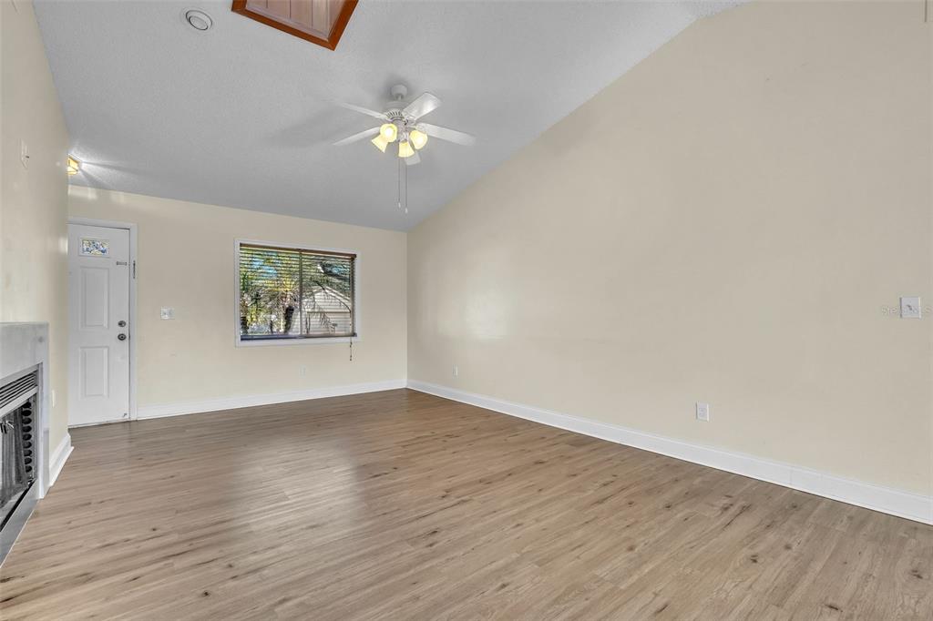 7724 Pengrove Pass Orlando, FL 32835 - Photo 7 of 24 an empty room with wooden floor and chandelier fan
