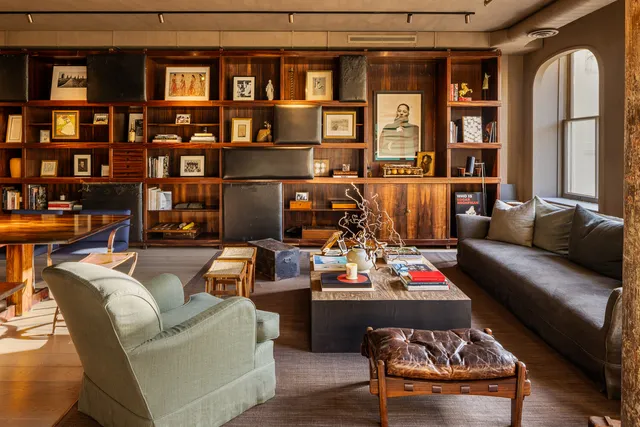 a living room with furniture and a book shelf