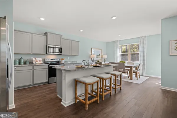 a kitchen with a sink a counter top space stainless steel appliances and cabinets