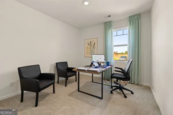 a view of a workspace with furniture and a window