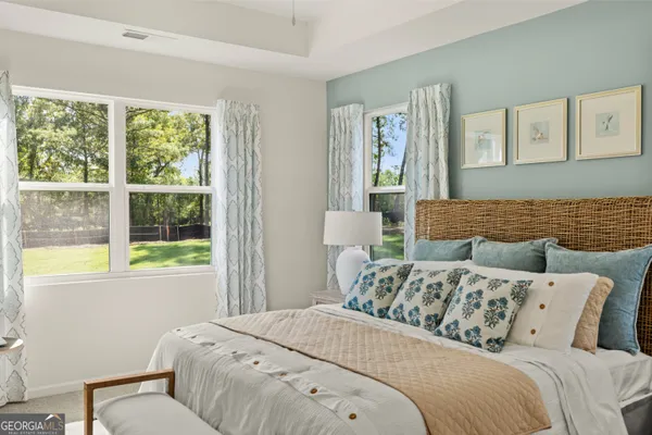 a house that is sitting in the grass with tress in the background