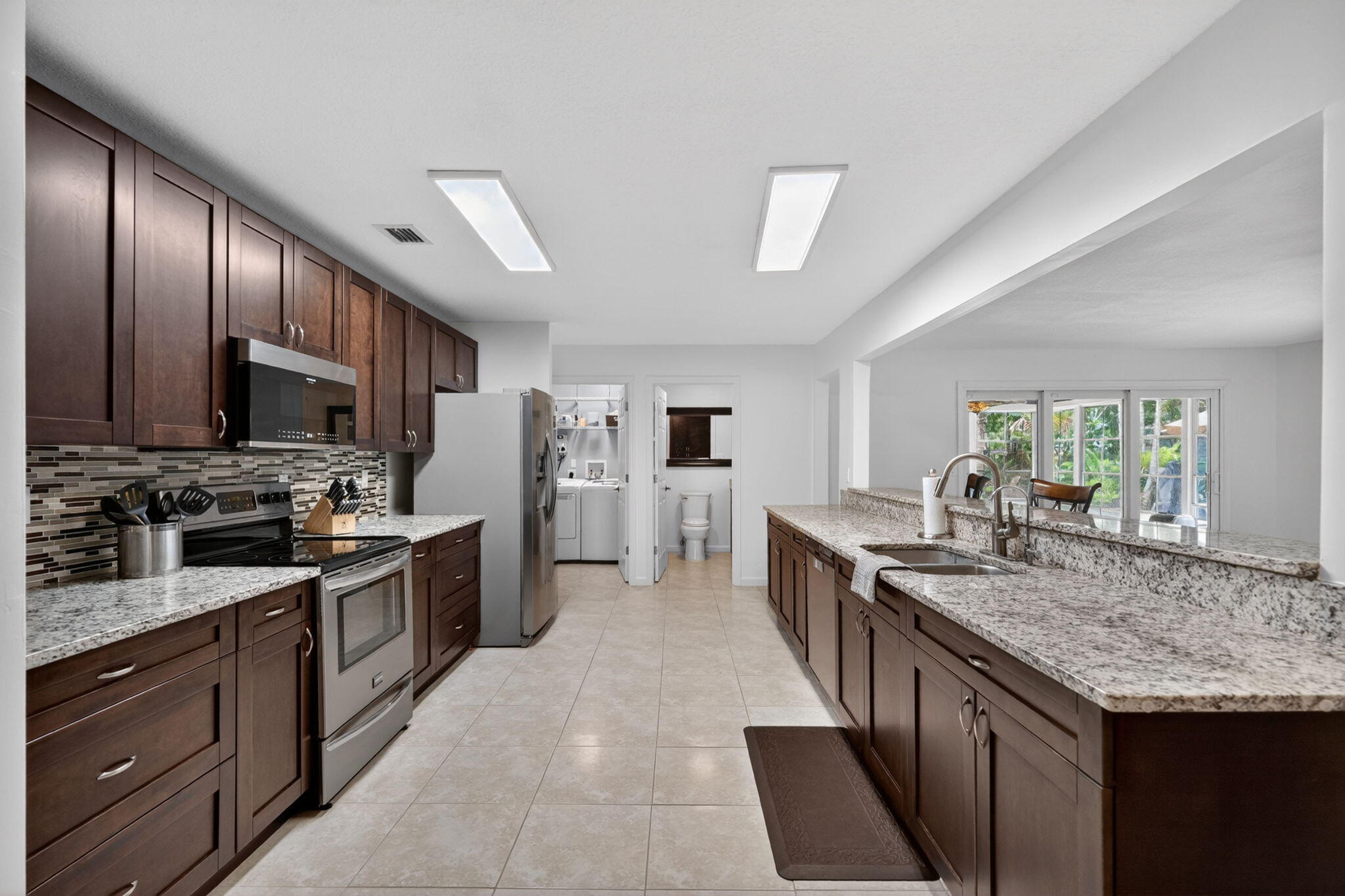 17391 Alexander Run Jupiter, FL 33478 - Photo 9 of 55 a kitchen with stainless steel appliances granite countertop lots of counter top space a refrigerator and cabinets