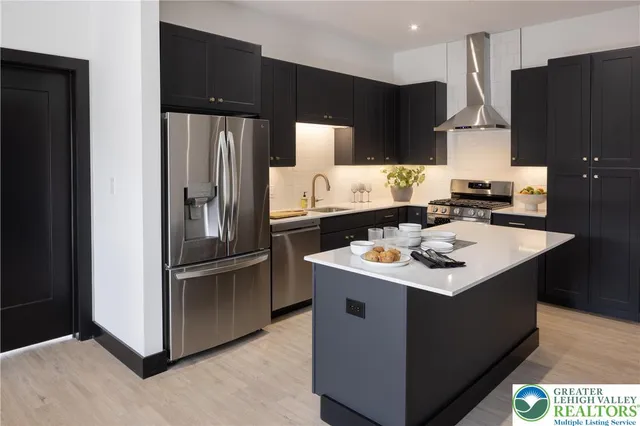 a kitchen with stainless steel appliances a sink stove and refrigerator