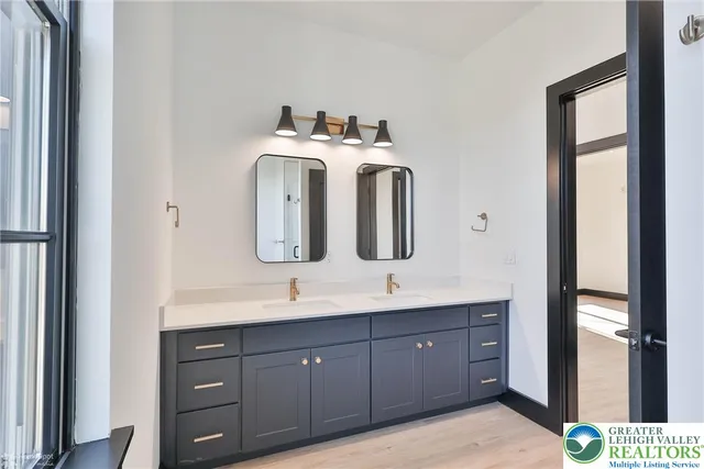 a bathroom with a double vanity sink and mirror