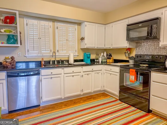 a kitchen with stainless steel appliances a sink a stove and cabinets