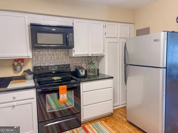 a kitchen with a refrigerator and a stove top oven