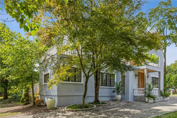 a front view of a house with a tree