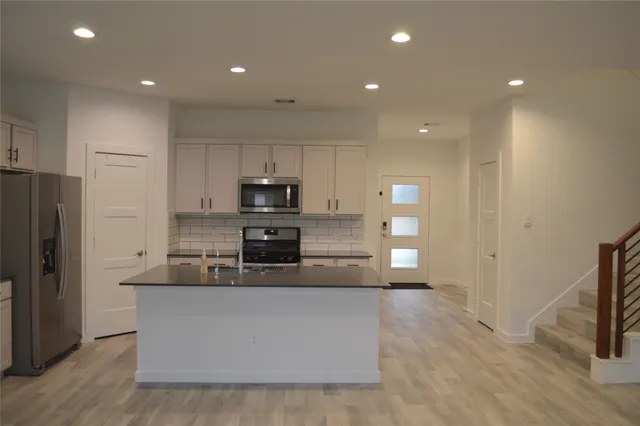 a large kitchen with stainless steel appliances and a refrigerator