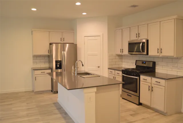 a kitchen with stainless steel appliances granite countertop a refrigerator and a stove