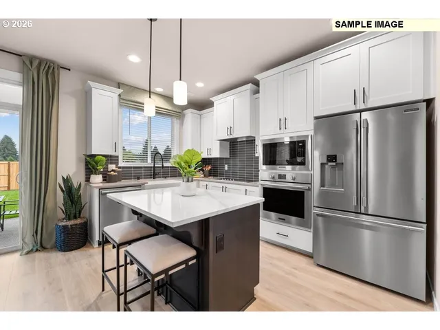 a kitchen with kitchen island white cabinets and stainless steel appliances