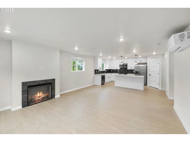 a view of kitchen with kitchen island white cabinets and refrigerator