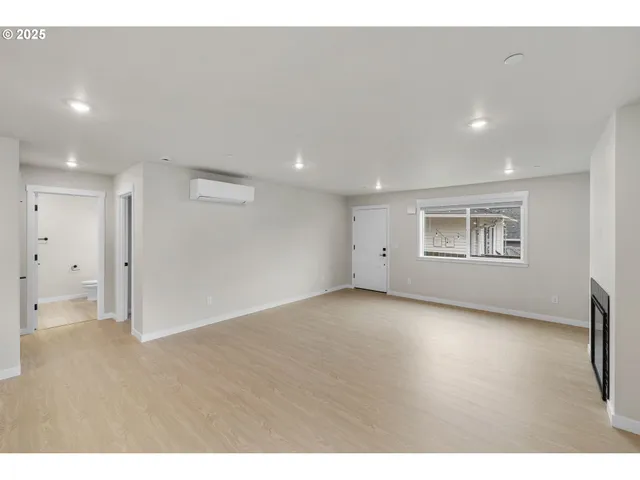 a large white kitchen with stainless steel appliances kitchen island granite countertop a refrigerator a stove top oven a sink and dishwasher