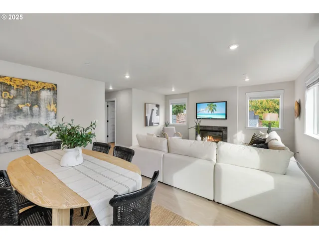 a living room with furniture a large window and kitchen view