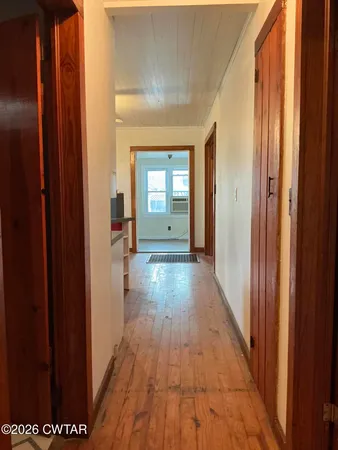 a view of a hallway with wooden floor and staircase