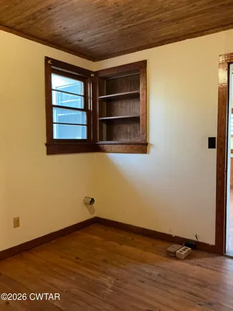 a view of a room with wooden floor and window