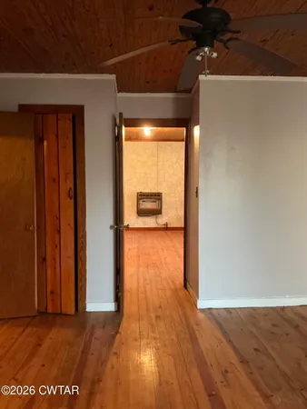 a view of a hallway with wooden floor