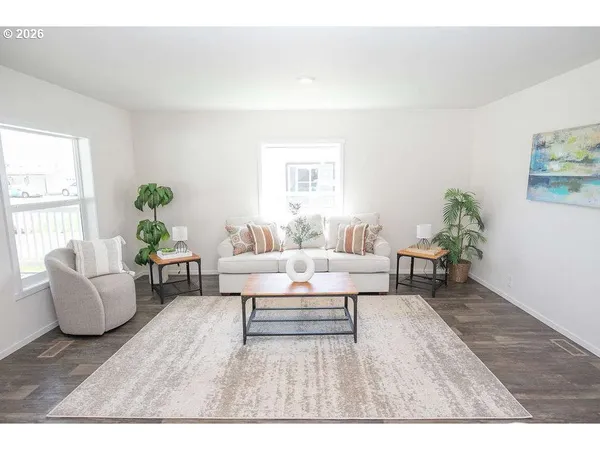 a kitchen with stainless steel appliances a dining table chairs refrigerator and microwave