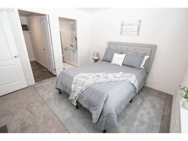 a bed sitting in a bedroom next to a bathroom