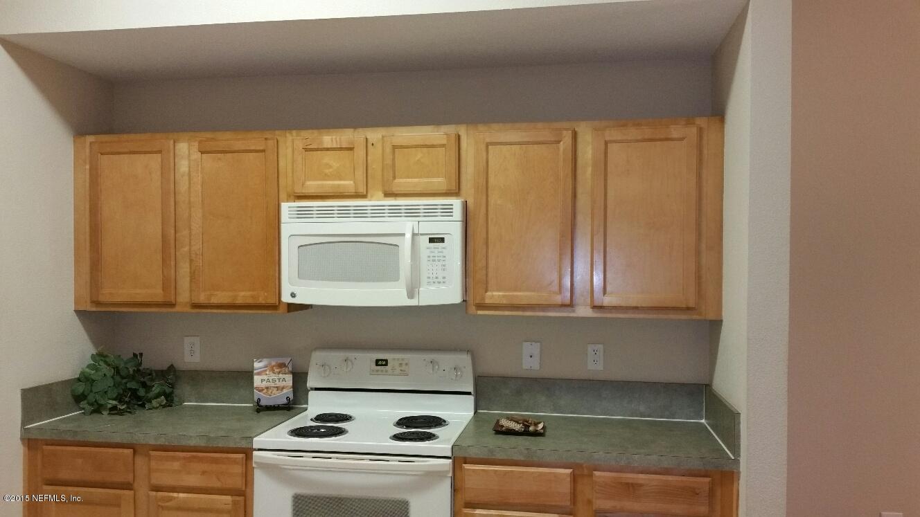 7920 Merrill Road, Unit 1804 Jacksonville, FL 32277 - Photo 7 of 35 a kitchen with granite countertop a sink a stove and cabinets