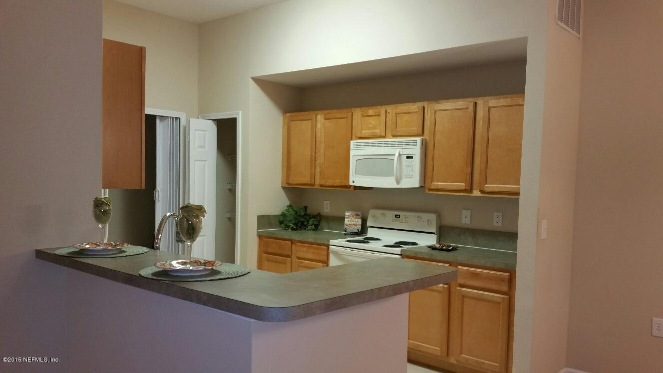 7920 Merrill Road, Unit 1804 Jacksonville, FL 32277 - Photo 8 of 35 a kitchen with kitchen island granite countertop a sink and a stove top oven