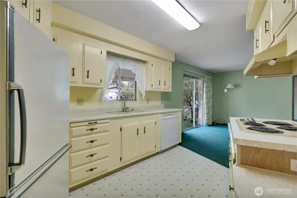 a kitchen with granite countertop a sink cabinets and stainless steel appliances