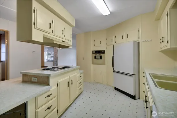 a kitchen with stainless steel appliances a stove a refrigerator and cabinets