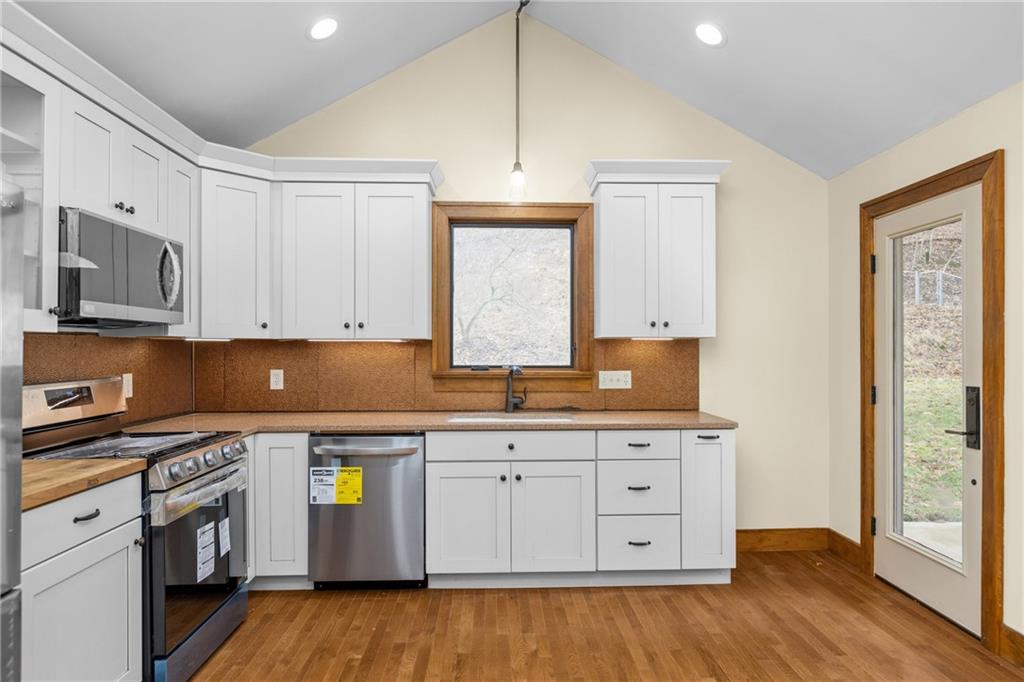 2 Quarry Road Sewickley, PA 15143 - Photo 14 of 29 a kitchen with stainless steel appliances a stove a sink and white cabinets with wooden floor