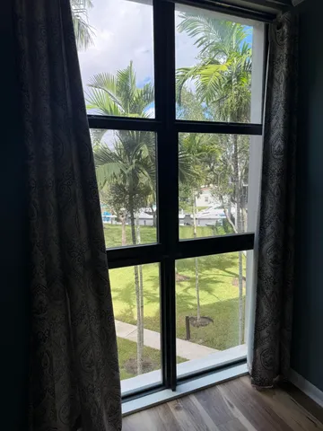 a view of an empty room with wooden floor and doors