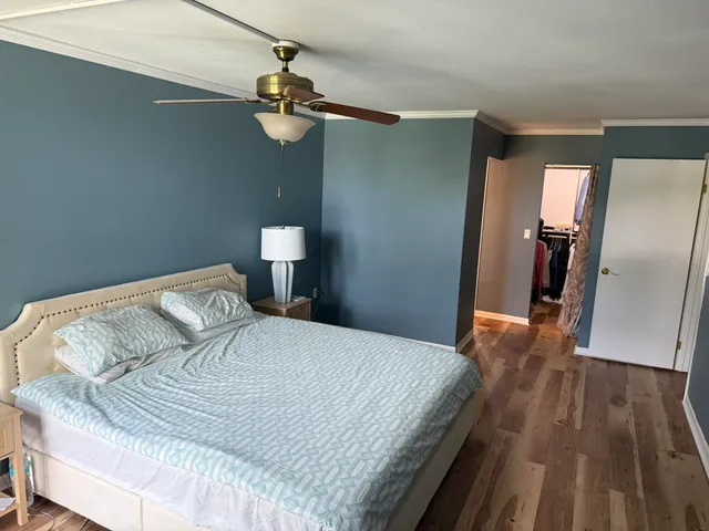 a bedroom with a bed and wooden floor