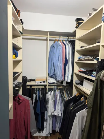 a view of walk in closet with clothes and shoes