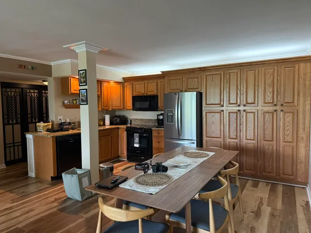 a kitchen with a table chairs refrigerator and microwave
