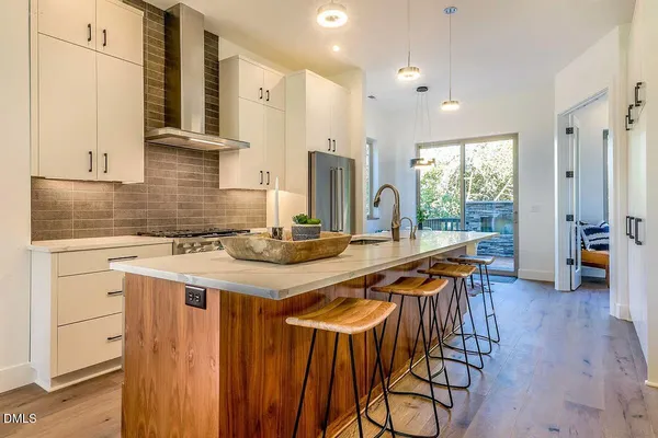 a kitchen with stainless steel appliances a table and chairs