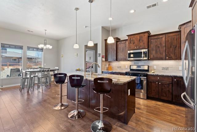 1326 Fairway Drive Fruita, CO 81521 - Photo 5 of 22 a kitchen with stainless steel appliances granite countertop a stove top oven a sink a dining table and chairs