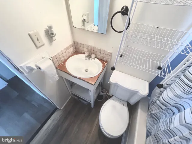 a bathroom with a toilet mirror a sink and a mirror