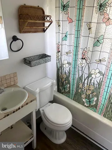 a bathroom with a toilet sink and shower curtain