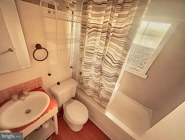 a bathroom with a sink a toilet and shower curtain